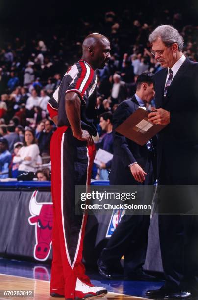 Michael Jordan and Phil Jackson of the Chicago Bulls talk against the New York Knicks during a game played circa 1998 at Madison Square Garden in New...