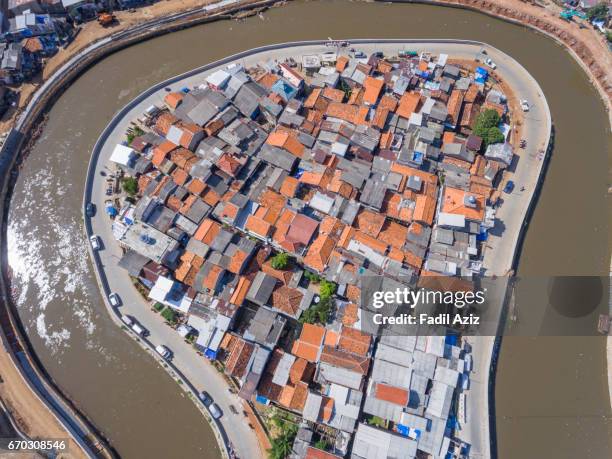 an "island" full of houses in jakarta's ciliwung river - jakarta slum stock pictures, royalty-free photos & images