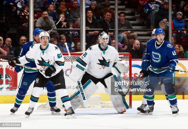 April 2: Justin Braun and Martin Jones of the San Jose Sharks and Henrik Sedin and Michael Chaput of the Vancouver Canucks watch the play during...