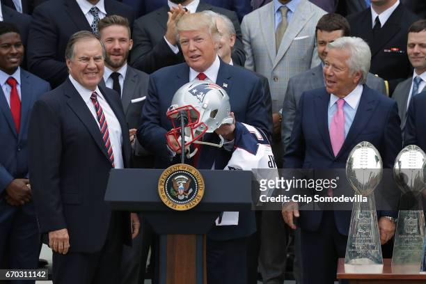 New England Patriots Head Coach Bill Belichick and team owner Robert Kraft present a football helmet to U.S. President Donald Trump during a...