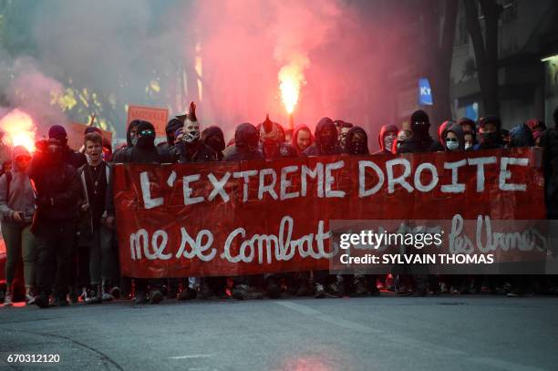 Demonstartors march behind a banner which translates as "The Extreme Right, you can't fight at the ballot box" as they stage a protest against the...