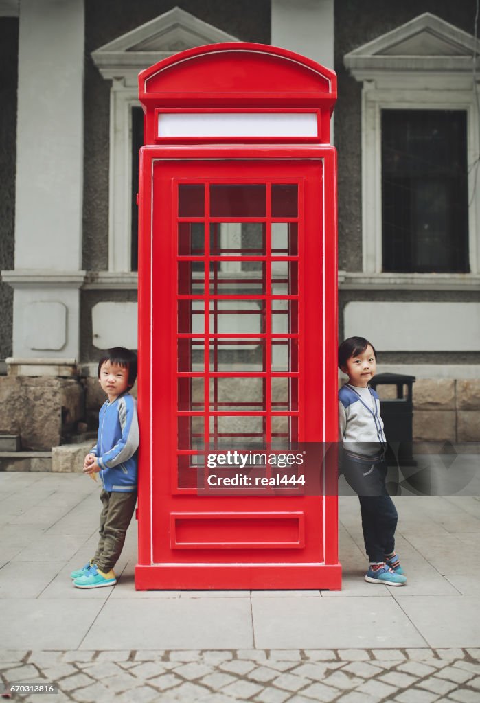 Enfants avec téléphone rouge boîte dans la ville