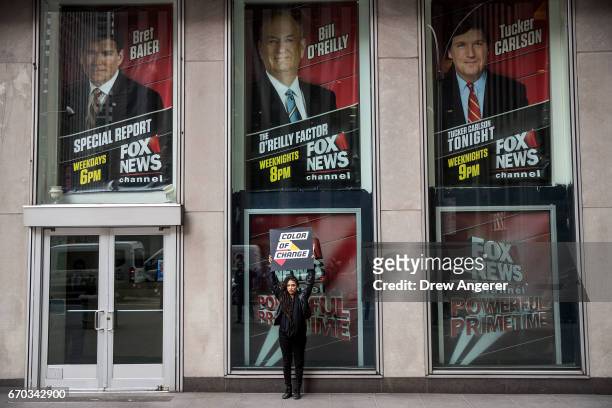 Demonstrator Anna Collier Navaroli holds a sign outside of the News Corp. And Fox News headquarters in Midtown Manhattan, April 19, 2017 in New York...