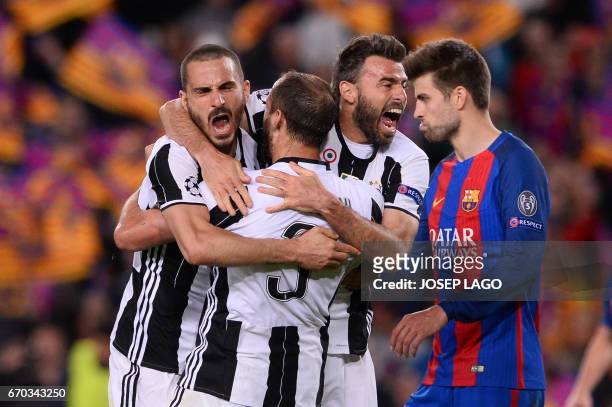 Juventus' defender Giorgio Chiellini celebrates their qualification with Juventus' defender Andrea Barzagli and a teammate at the end of the UEFA...