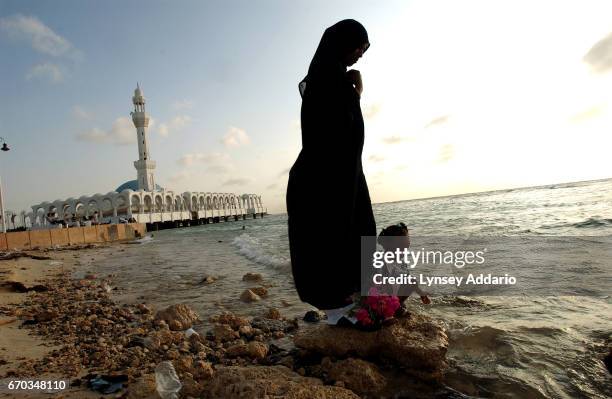 Woman stands in the sea outside the mosque along the beach in Jeddah, Saudi Arabia, December 19, 2003. Since the terrorism attacks in New York on...