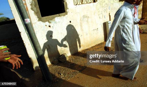 Children run through the streets in the village of Ghut Ghut, outside Riyadh, Arabia, December 2003.