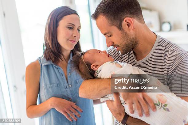 parents hold baby girl, lovingly - sleeveless shirt stock pictures, royalty-free photos & images