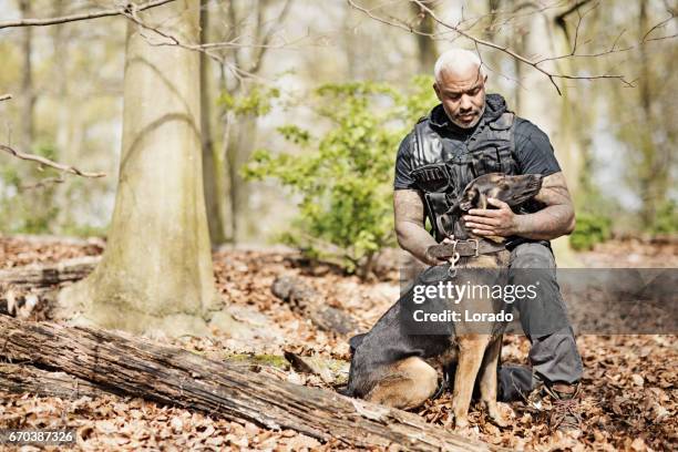 handsome black middle aged security agent working with guard dog in woodlands - handsome military men stock pictures, royalty-free photos & images