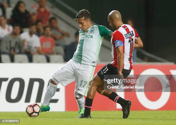 Dayro Moreno of Atletico Nacional fights defends the ball from Juan Sebastian Veron of Estudiantes during a group stage match between Estudiantes and...