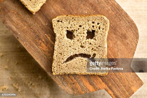 a slice of bread toast with a sad face - celiac disease stock pictures, royalty-free photos & images