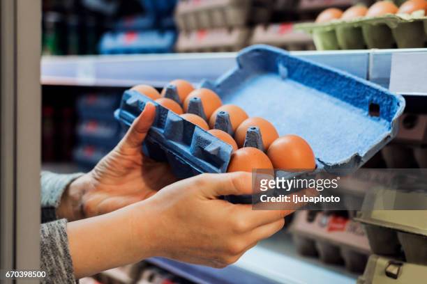 het kopen van eieren in een supermarkt - carton of eggs stockfoto's en -beelden