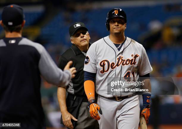 Victor Martinez the Detroit Tigers walks away after grounding out to first base as manager Brad Ausmus of comes out to question home plate umpire...