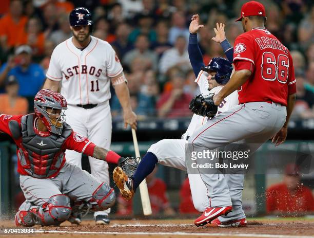 Jose Altuve of the Houston Astros is tagged out by Martin Maldonado of the Los Angeles Angels of Anaheim as he attempted to score on a pitch from JC...