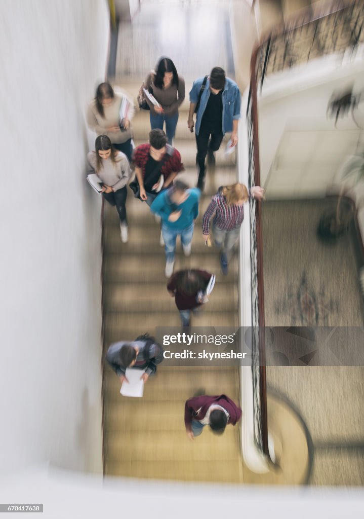 Above view of students walking down the stairs in blurred motion.