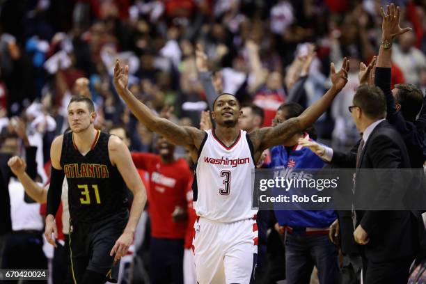 Bradley Beal of the Washington Wizards celebrates in front of Mike Muscala of the Atlanta Hawks after hitting a three pointer in the second half of...