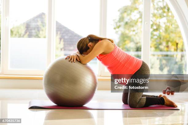 half volwassen zwangere vrouw is uitoefenen met een bal - woman kneeling stockfoto's en -beelden