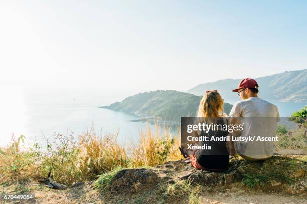 young couple relax, on hillside above sea - asian young couple stock pictures, royalty-free photos & images