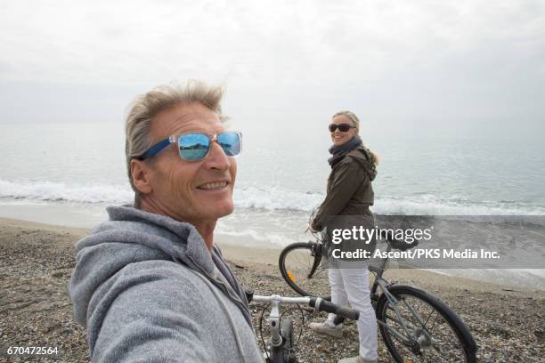biking couple pause at beach edge, take selfie - sunglasses reflection stock pictures, royalty-free photos & images