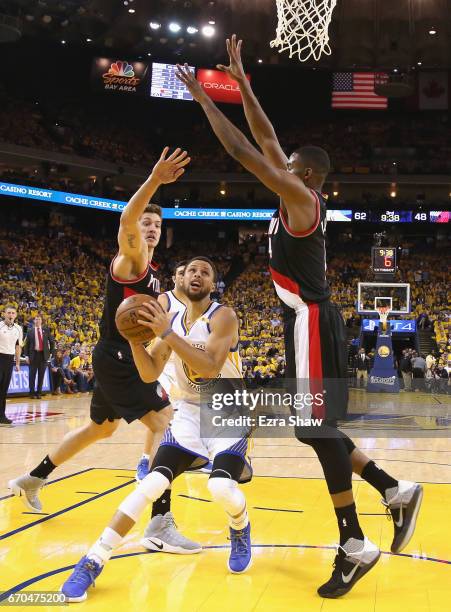 Stephen Curry of the Golden State Warriors goes up for a shot against Maurice Harkless and Meyers Leonard of the Portland Trail Blazers Game Two of...