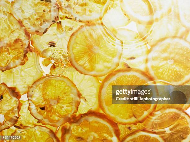 lemon slices under water - lemons stock-fotos und bilder