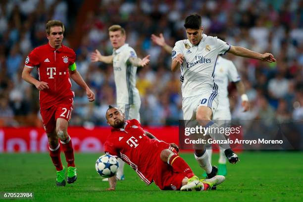 Arturo Vidal of Bayern Muenchen tackles Marco Asensio of Real Madrid CF during the UEFA Champions League Quarter Final second leg match between Real...