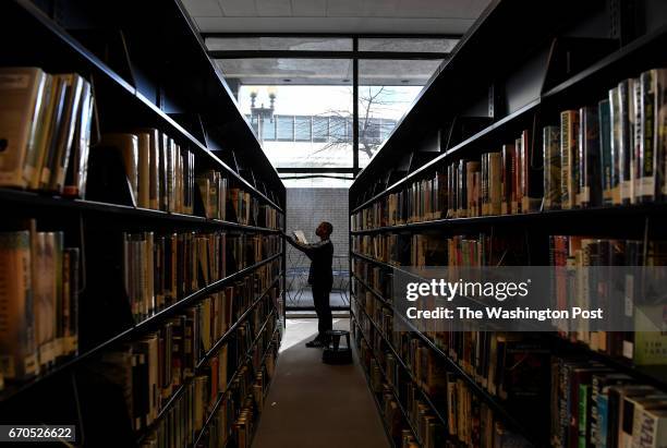 Library associate Caleb Bess pulls books from the shelves to be assessed at the Martin Luther King, Jr., Memorial Library on March 8, 2016 in...
