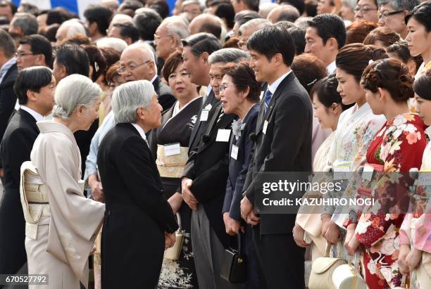 Japan's Emperor Akihito and Empress Michiko greet guests during the spring garden party at the Akasaka Palace imperial garden in Tokyo on April 20,...