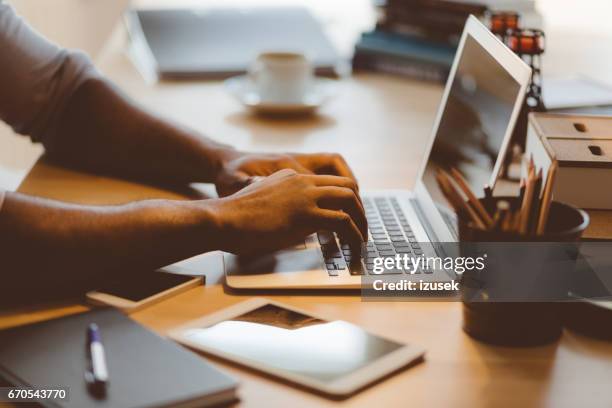 afro american young man typing on laptop - email marketing stock pictures, royalty-free photos & images