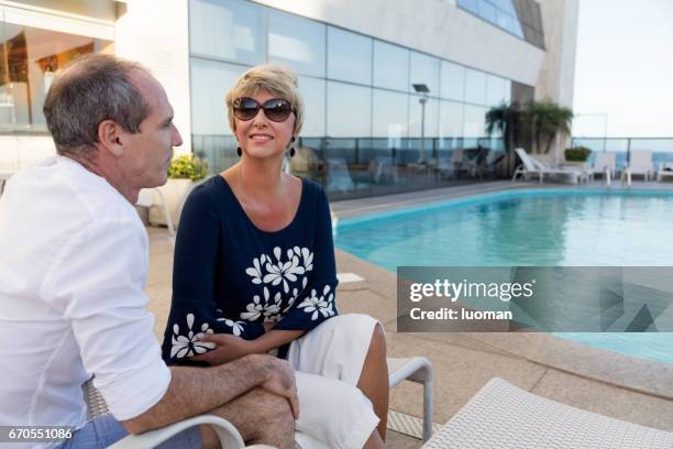 pareja en la piscina de media edad - roupa descontraída fotografías e imágenes de stock