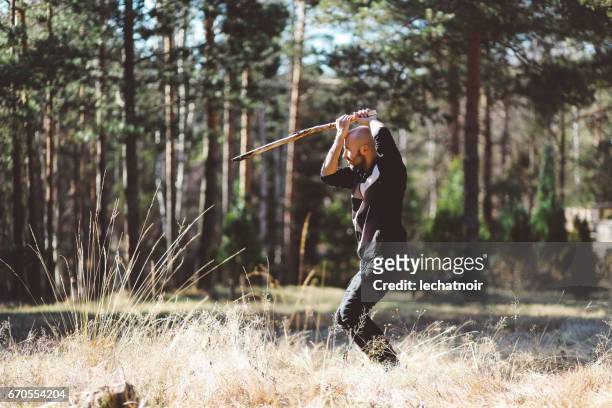 junger mann training kampfkünste in der natur - samurai stock-fotos und bilder