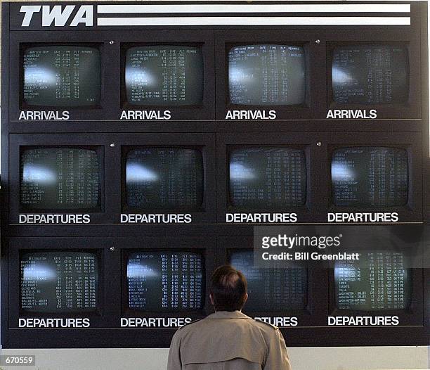 Traveler checks flight information at a bank of Trans world Airlines monitors in the main terminal, January 9, 2001 at Lambert-St. Louis...