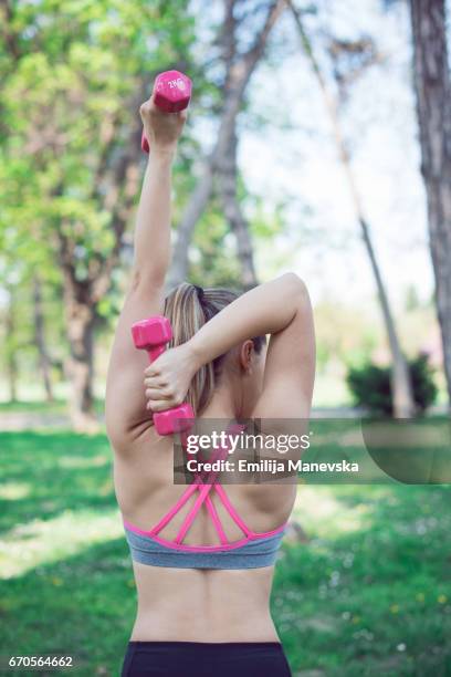 young woman lifting weights - weight lifting imagens e fotografias de stock