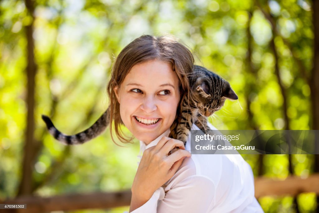 Belle jeune femme jouissant avec son chat sur les épaules