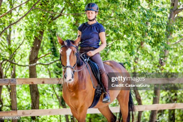 jonge vrouw rijdt paard in de manege - langzaam stockfoto's en -beelden