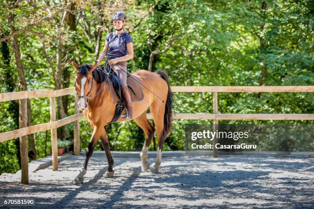 jonge vrouw rijdt paard in de manege - slow stockfoto's en -beelden