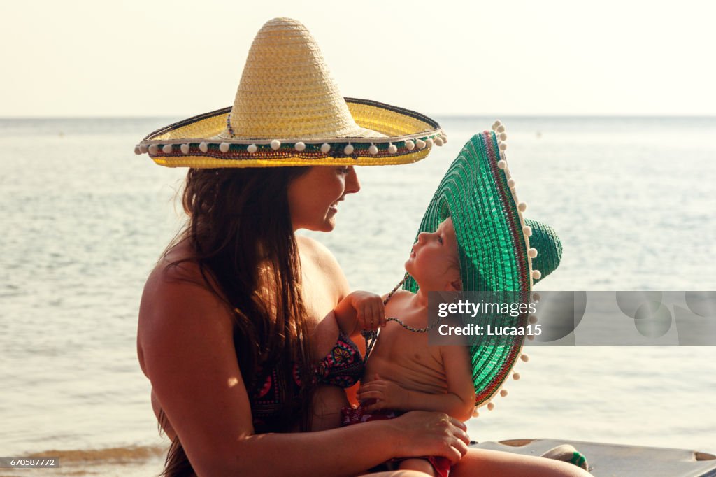 Smiling mother and her baby on the beach