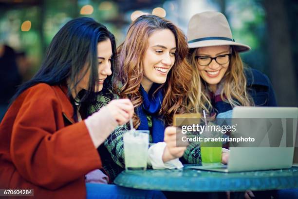 freundinnen kaufen online in der cafeteria ein - cocktail counter stock-fotos und bilder