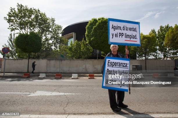 Protester holds placards as Esperanza Aguirre appears at the National Court as a witness in the Gurtel case on April 20, 2017 in San Fernando de...