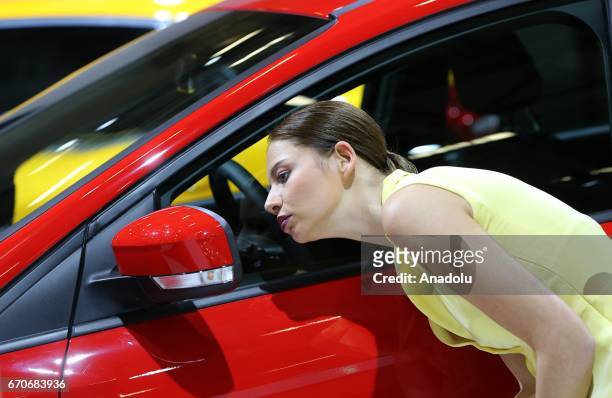 Woman looks herself from wing mirror of Hyundai i30 during the Istanbul Autoshow 2017 at the TUYAP Fair and Convention Center in Istanbul, Turkey on...