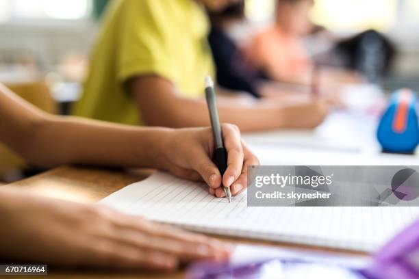 close up of left handed school child writing in notebook. - left imagens e fotografias de stock