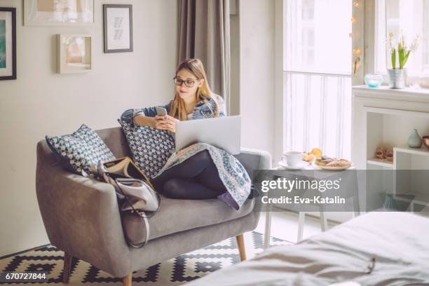 young woman at home - premium with mobile stock pictures, royalty-free photos & images