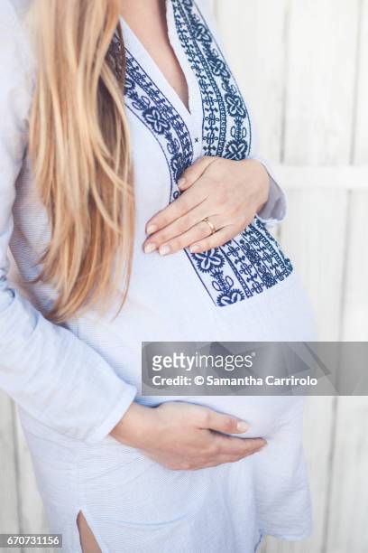 donna incinta. mani sul pancione. camicia a righe con ricamo. - crescita 個照片及圖片檔