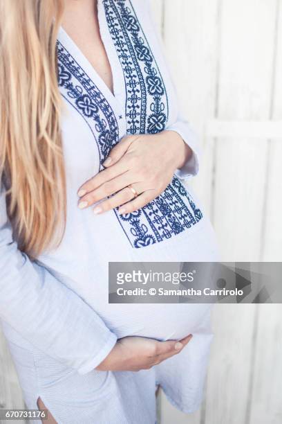 donna incinta. mani sul pancione. camicia a righe con ricamo. - crescita stock pictures, royalty-free photos & images