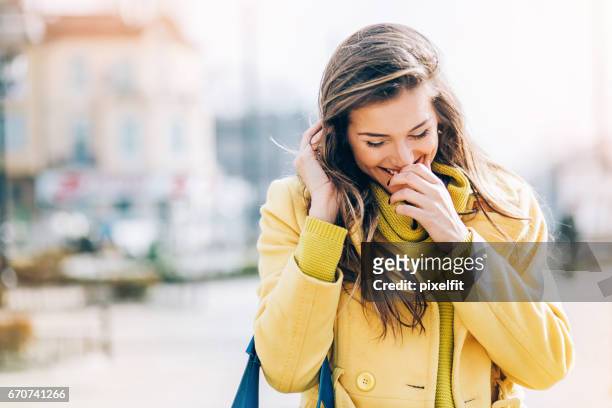 shy young woman smiling outdoors at sunlight - shy stock pictures, royalty-free photos & images