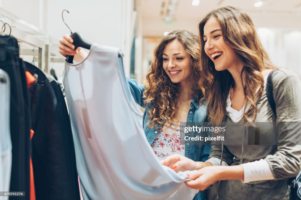 Zwei fröhliche Mädchen Kleidung kaufen