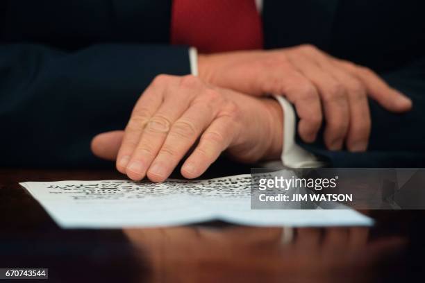 President Donald Trump reads from notes before signing the Memorandum Regarding the Investigation Pursuant to Section 232 of the Trade Expansion Act...