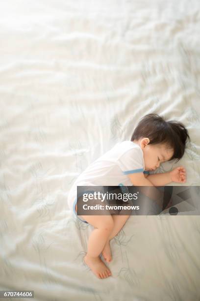 toddler sleeping peacefully on bed. - bed on white background stock-fotos und bilder