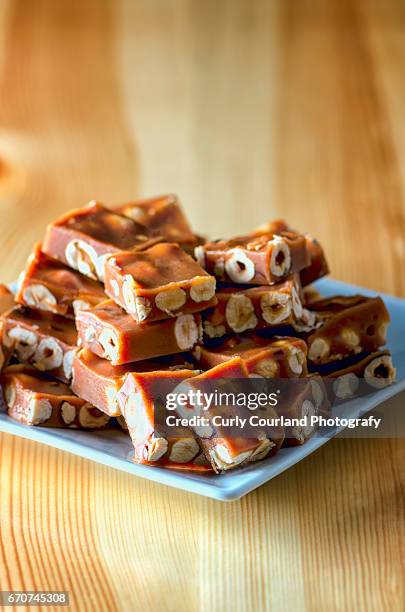 caramelled nougat candy with hazel nuts served on the rectangular plate - nougat stock-fotos und bilder