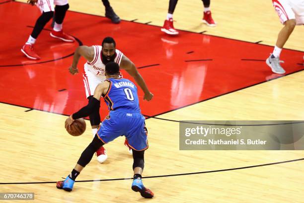 Russell Westbrook of the Oklahoma City Thunder dribbles the ball while guarded by James Harden of the Houston Rockets during Game Two of the Western...