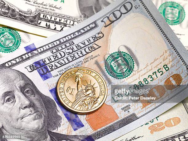 close up of $100 dollar note and 1 dollar coin - moeda de um dólar dos estados unidos imagens e fotografias de stock